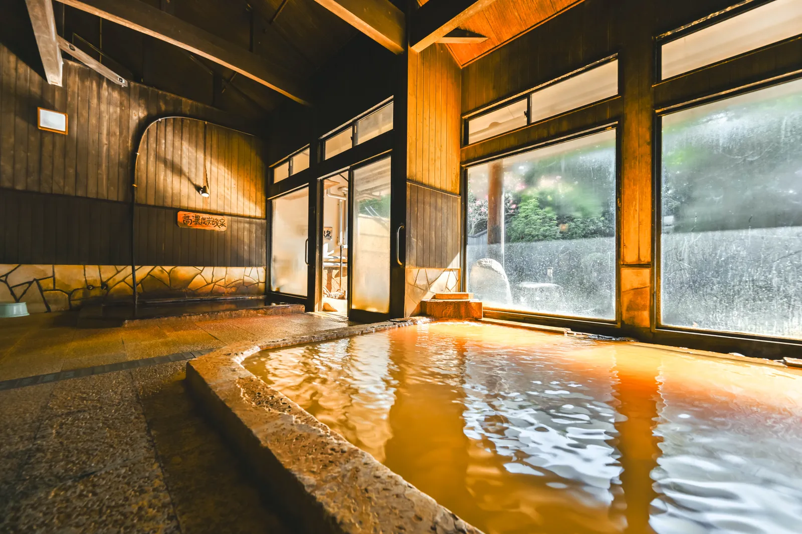 夕暮れの光が差すにごり湯の内湯